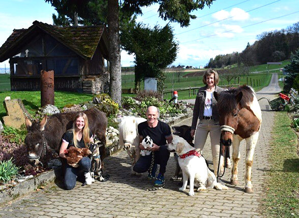 Familie Volkart im Mösli posiert mit Tieren fürs Familienfoto
